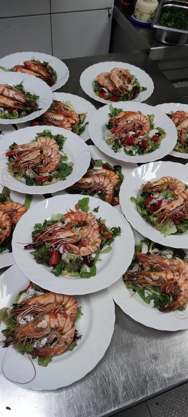 Ein Haufen Teller mit Essen und Garnelen darauf