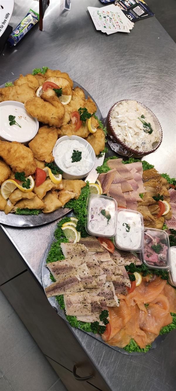 Auf einer Theke stehen zwei Tabletts mit Essen.