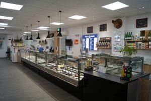 Ein Lebensmittelladen mit einer langen Vitrine und einer Theke.