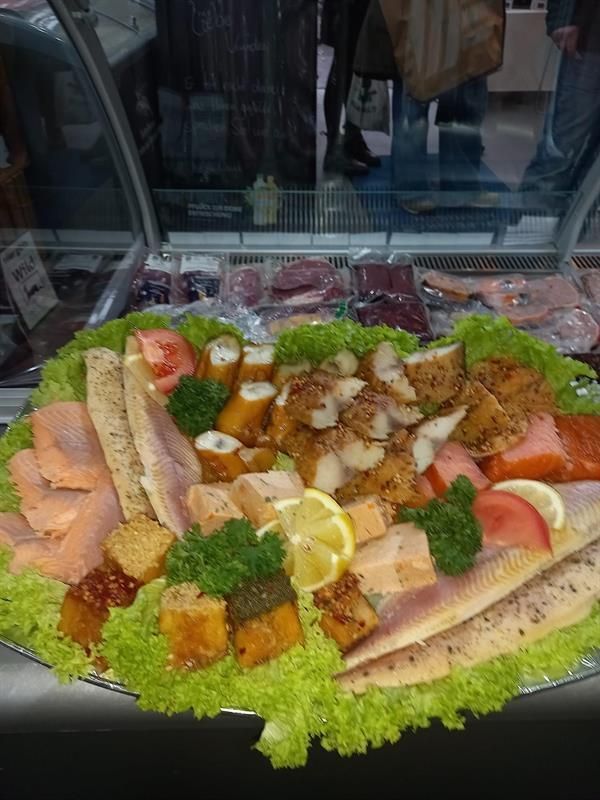 Ein Teller mit Salat, Tomaten, Zitronen und anderem Gemüse auf einem Tisch.