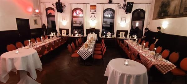 Ein großer Raum mit Tischen und Stühlen für eine Party