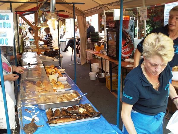 Eine Frau steht vor einem Tisch mit Essen und einem Schild mit der Aufschrift „Herte“ darauf