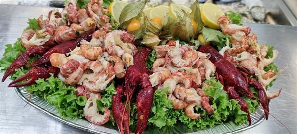 Ein Teller mit Garnelen und Langusten auf Salat auf einem Tisch.