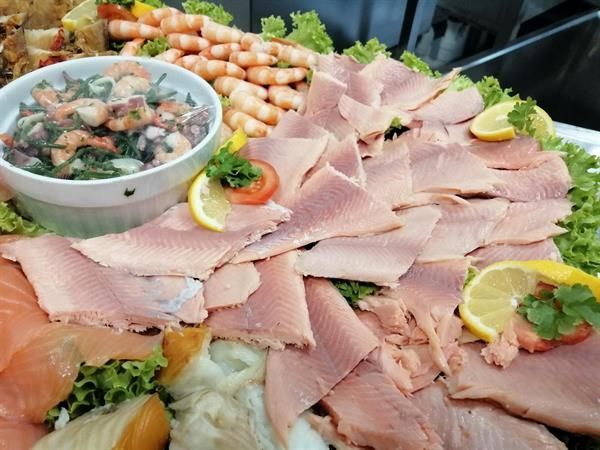 Ein Teller mit Fleisch und Garnelen darauf