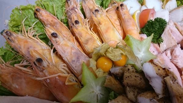 Eine Nahaufnahme eines Tellers mit Garnelen und Gemüse.