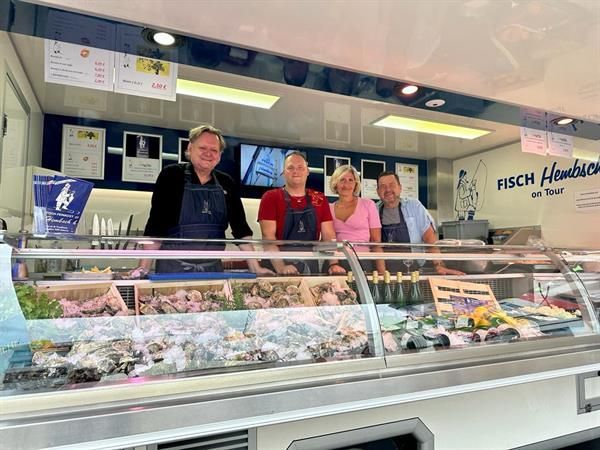 Eine Gruppe von Menschen steht vor einer Vitrine.