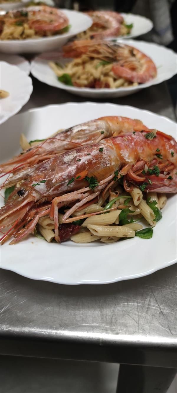 Ein Teller mit Garnelen und Nudeln auf einem Tisch.