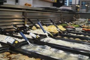 Ein Buffet in einem Lebensmittelgeschäft mit vielen Lebensmitteln und Utensilien.