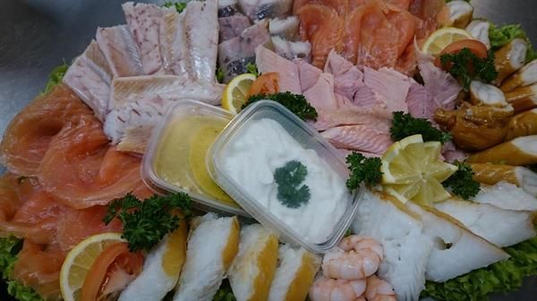 Ein Teller mit Essen und einem Behälter mit saurer Sahne darauf.