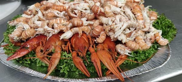 Ein Teller mit Garnelen und Krabben auf Salat auf einem Tisch.