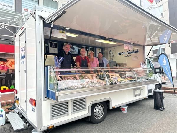 Eine Gruppe von Leuten steht vor einem Imbisswagen.