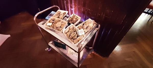 Auf einem Holzboden steht ein Wagen voller Kisten mit Lebensmitteln.