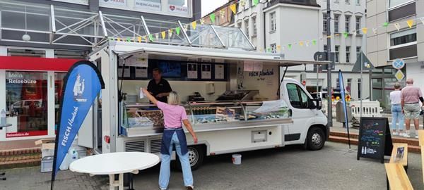 Eine Frau steht vor einem Imbisswagen.