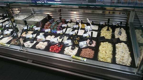 Eine Vitrine mit vielen unterschiedlichen Arten von Lebensmitteln in einem Lebensmittelgeschäft.