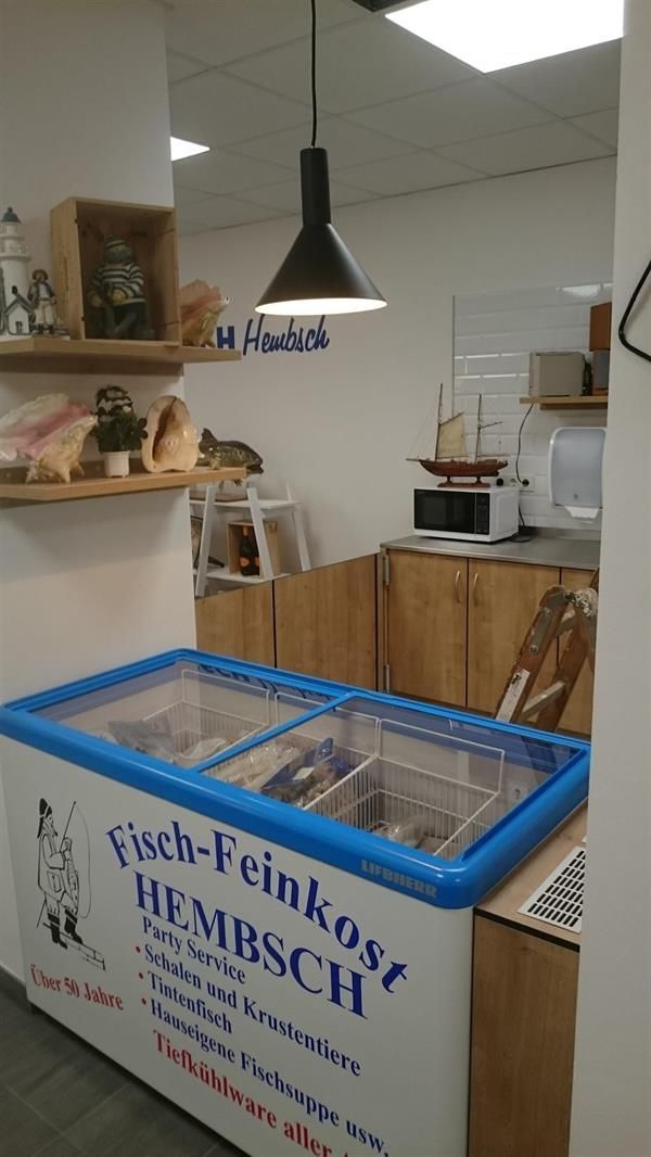 A freezer in a kitchen that says fisch feinkost hembsch