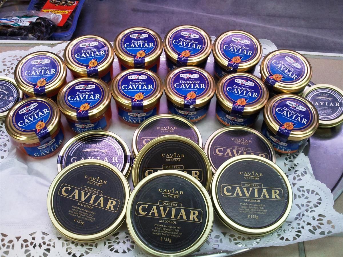Mehrere Gläser mit Kaviar stehen auf einem Tisch aufgereiht
