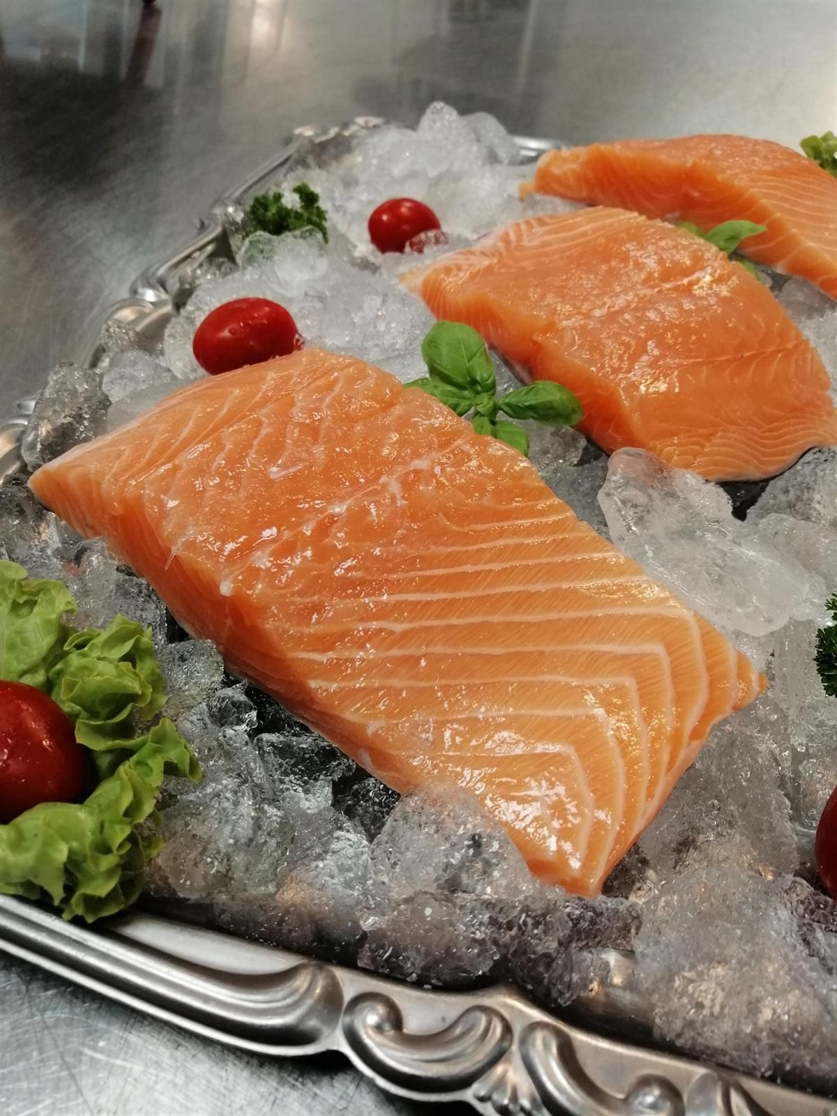 Eine Schale Lachs auf Eis mit Salat und Tomaten