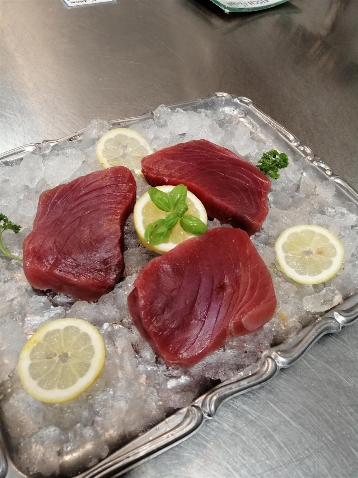 Ein Tablett mit Fleisch und Zitronenscheiben auf Eis