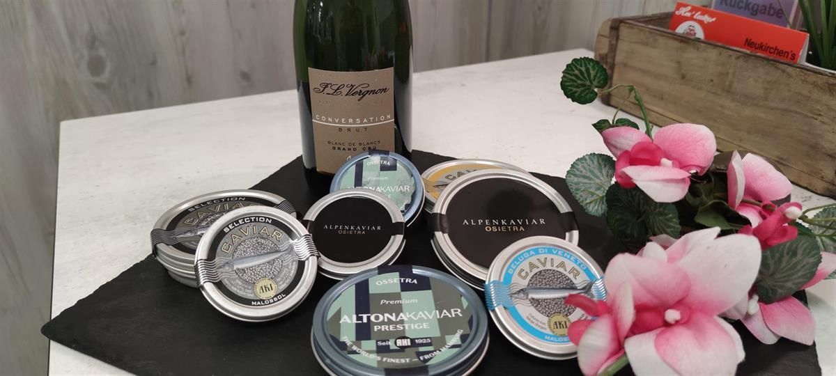 Eine Flasche Champagner steht auf einem Tisch, umgeben von Blumen