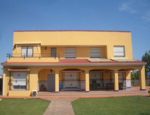 Una gran casa amarilla con techo rojo