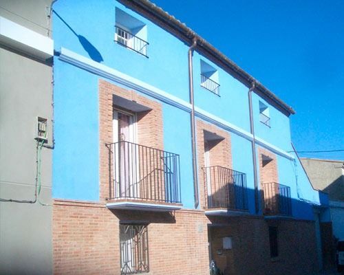 Un edificio azul con balcones a los lados.