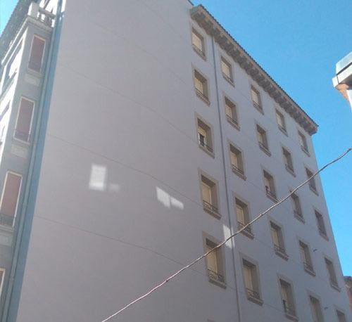 Mirando hacia arriba a un edificio alto con un cielo azul en el fondo