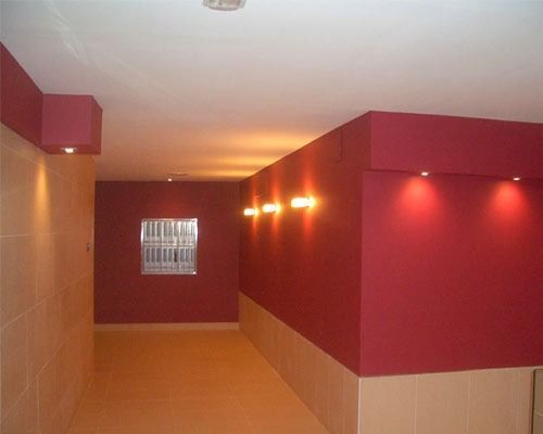 Un pasillo con paredes rojas y una ventana en la pared.