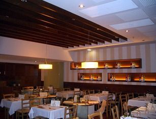 Un restaurante con mesas y sillas y una pared rayada.