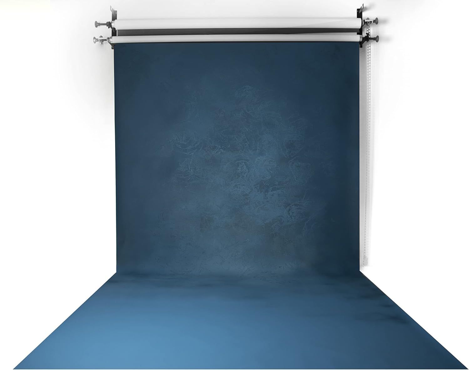 Fondo azul en un estudio de fotografía, preparado para un retrato con una pared y un suelo texturizados.