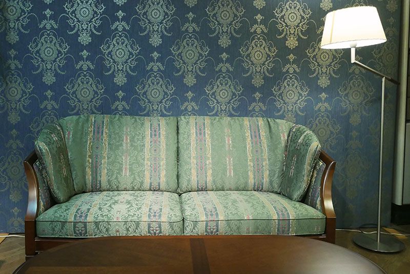 Ein Wohnzimmer mit einer grünen Couch und einer Lampe