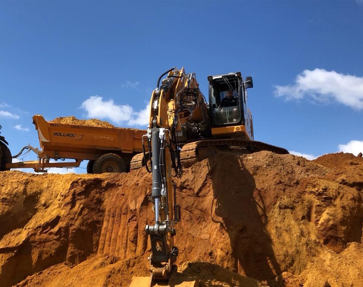 Pelleteuse réalisant des travaux de terrassement sous un ciel bleu