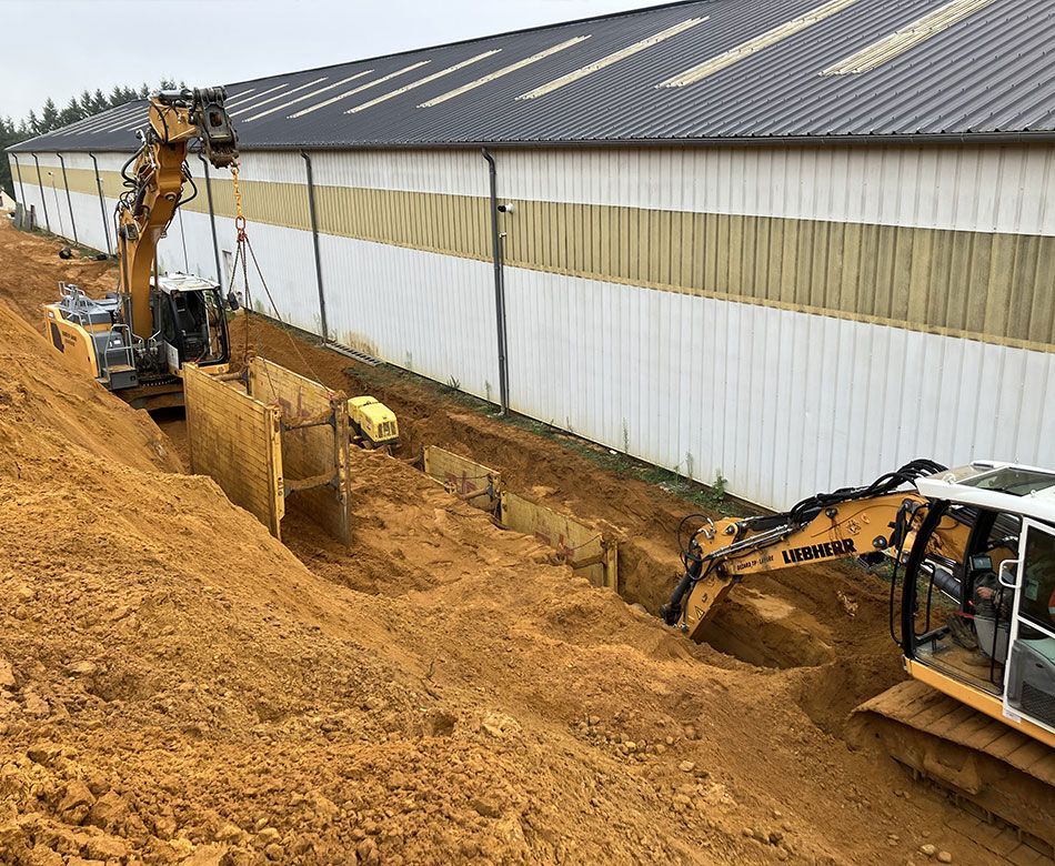 Pelleteuses creusant une tranchée pour la réalisation d'un réseau d'assainissement collectif