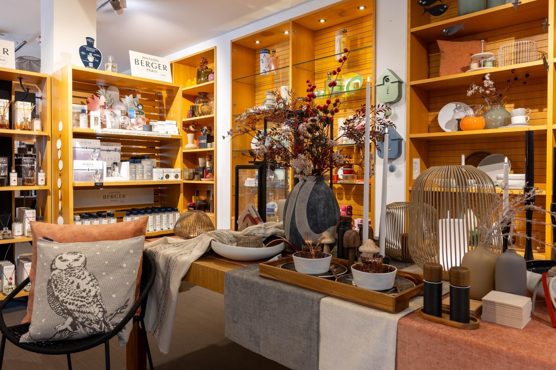 Innenansicht eines Ladens mit Regalen voller Dekorationsartikel, darunter Vasen, Kissen und Kerzen.