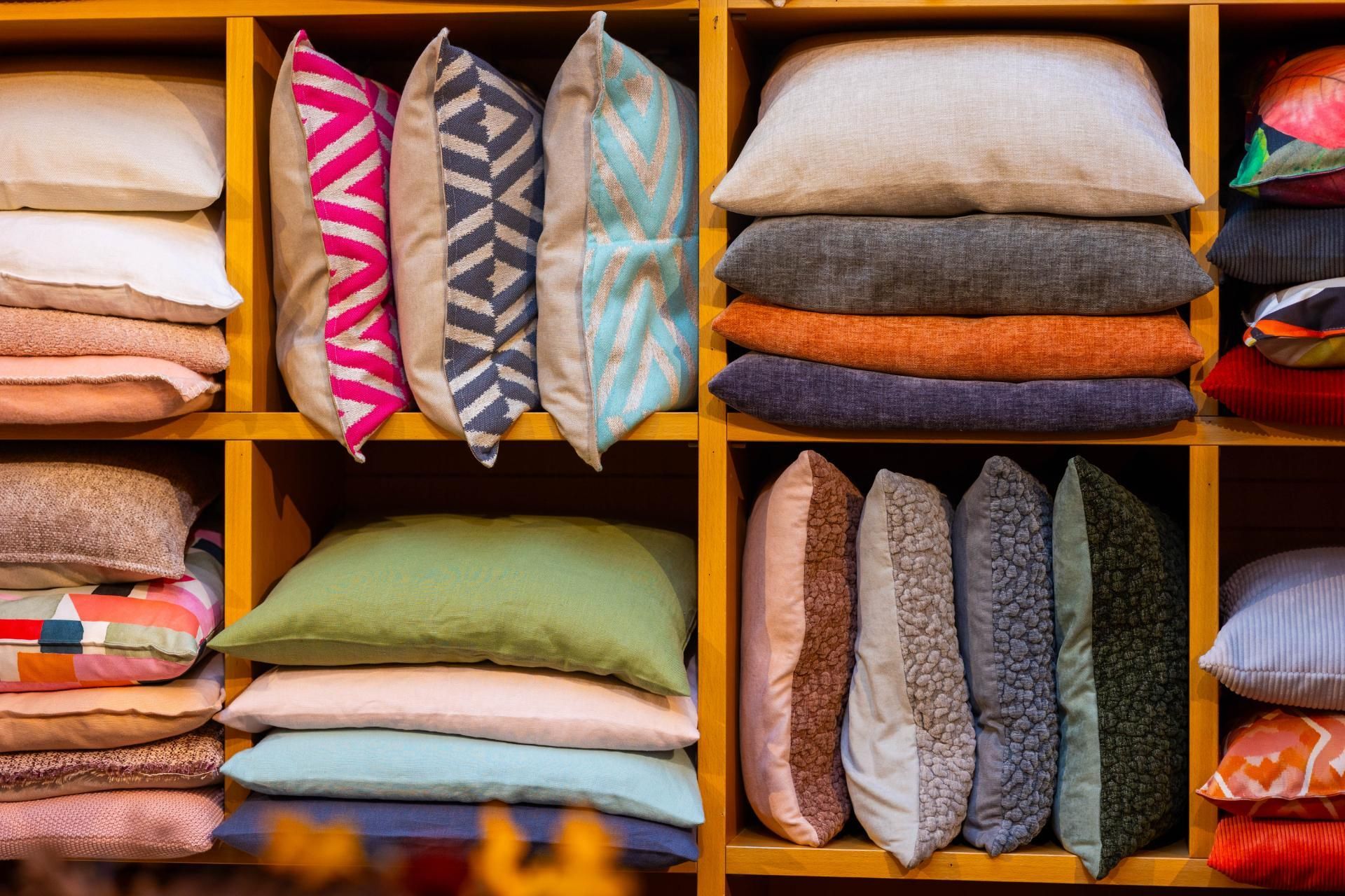 Regale gefüllt mit verschiedenen bunten Kissen.