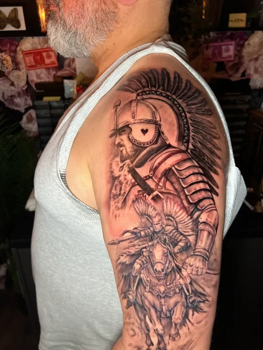 Tatuaje de un soldado romano a caballo con un casco de gladiador en un brazo.