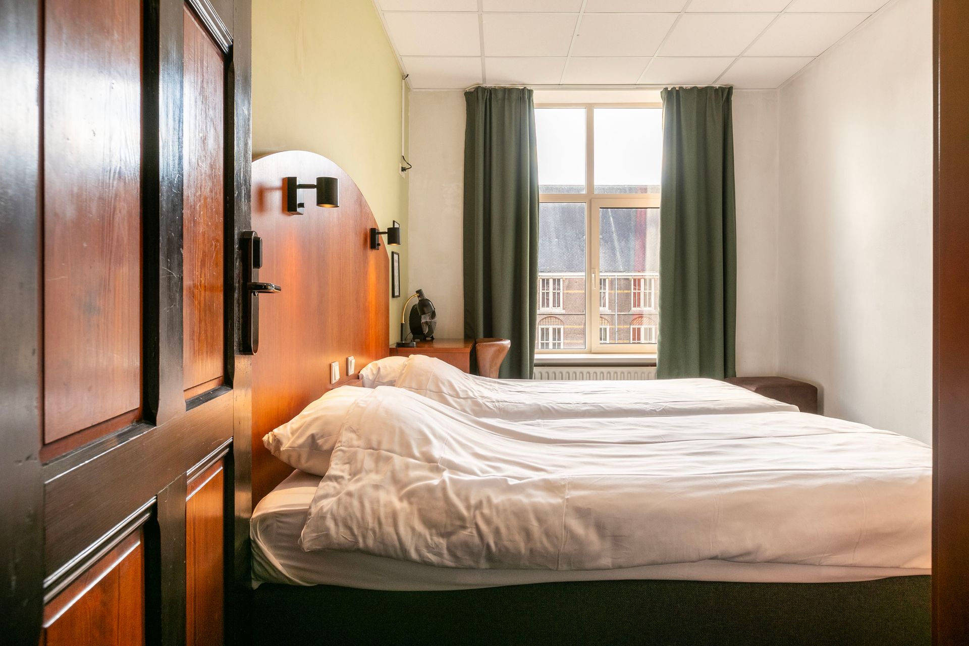 Een hotelkamer met twee bedden en een raam.