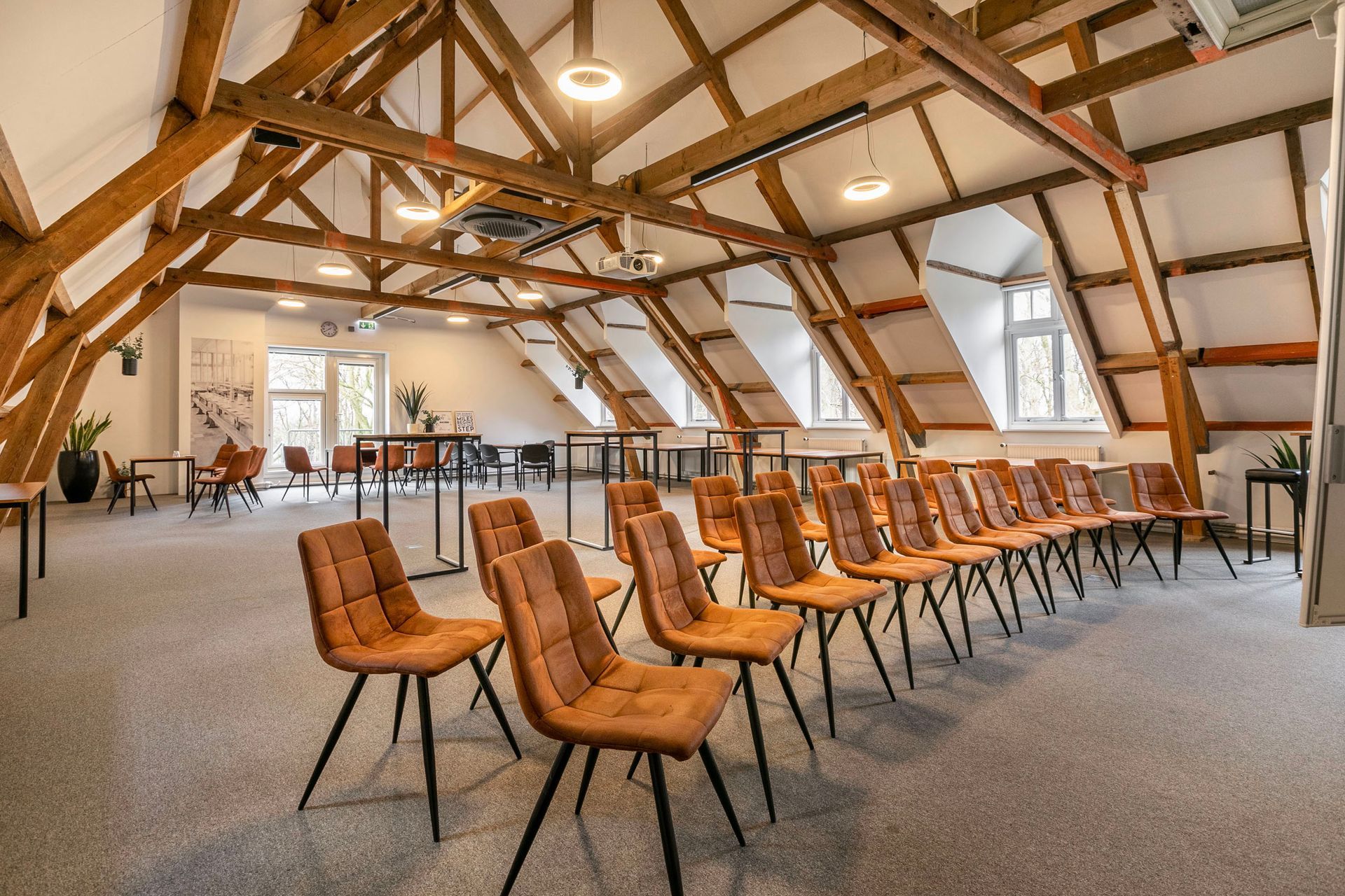 Een grote kamer met veel stoelen en tafels.