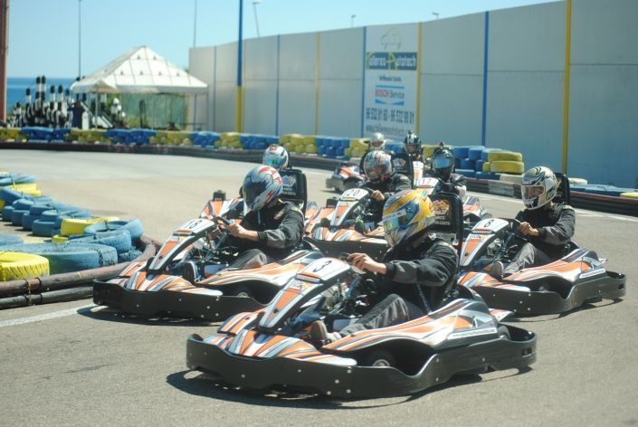 Un grupo de personas conduce karts en una pista.