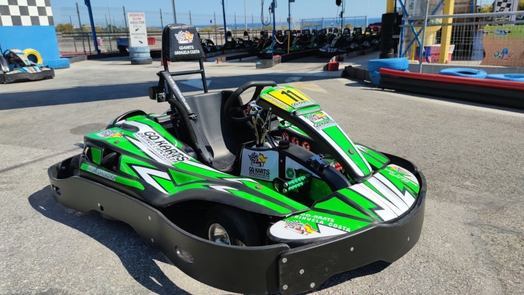 Un kart verde y blanco está estacionado al costado de la carretera.