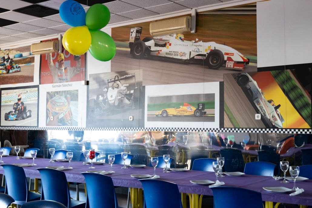 Un comedor con mesa y sillas y globos colgando del techo.