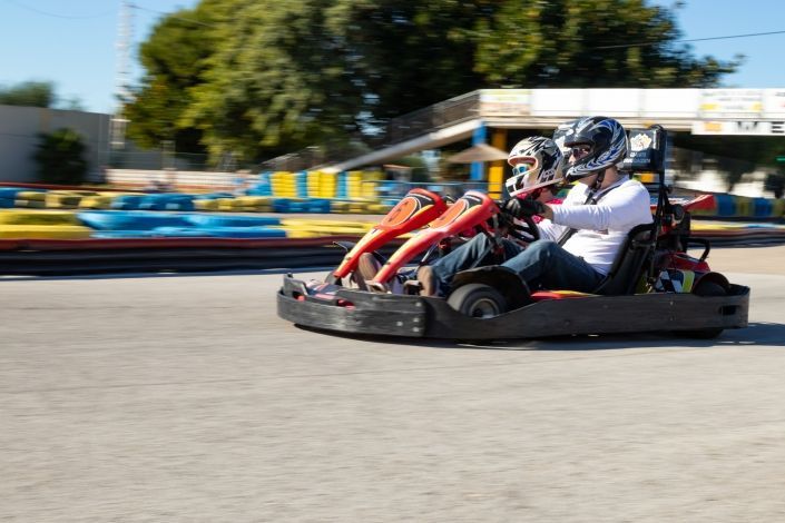 Dos personas viajan en un kart en una pista.