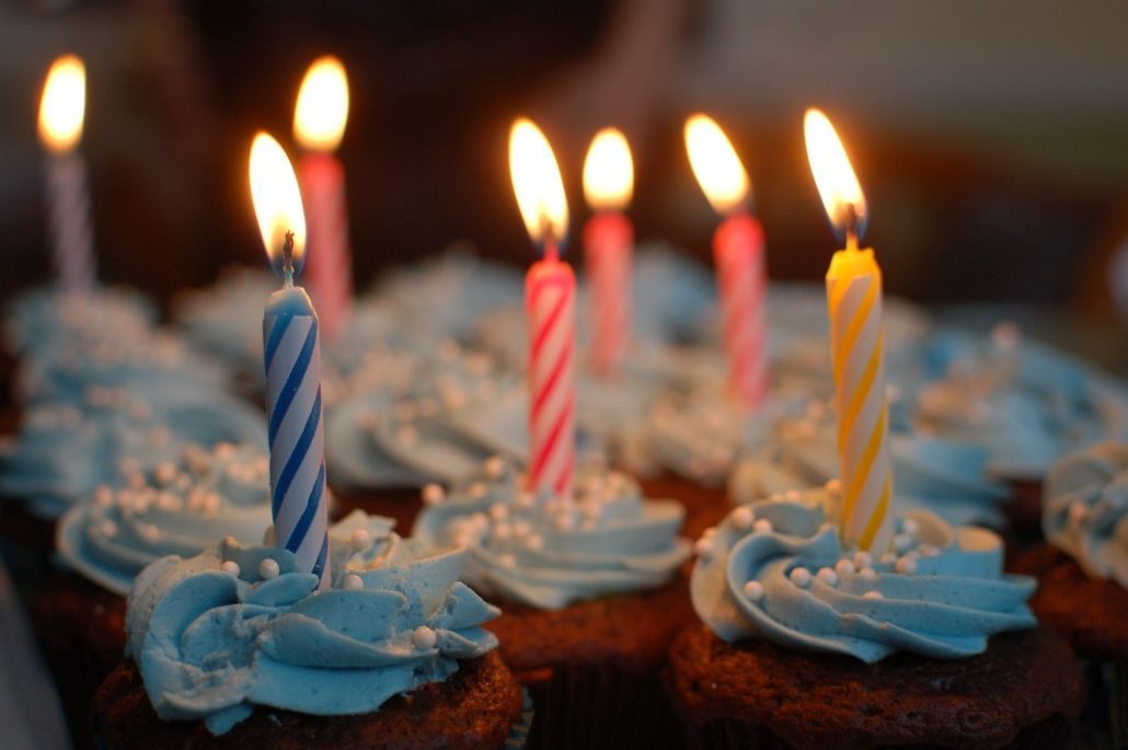 Un montón de cupcakes de cumpleaños con velas.