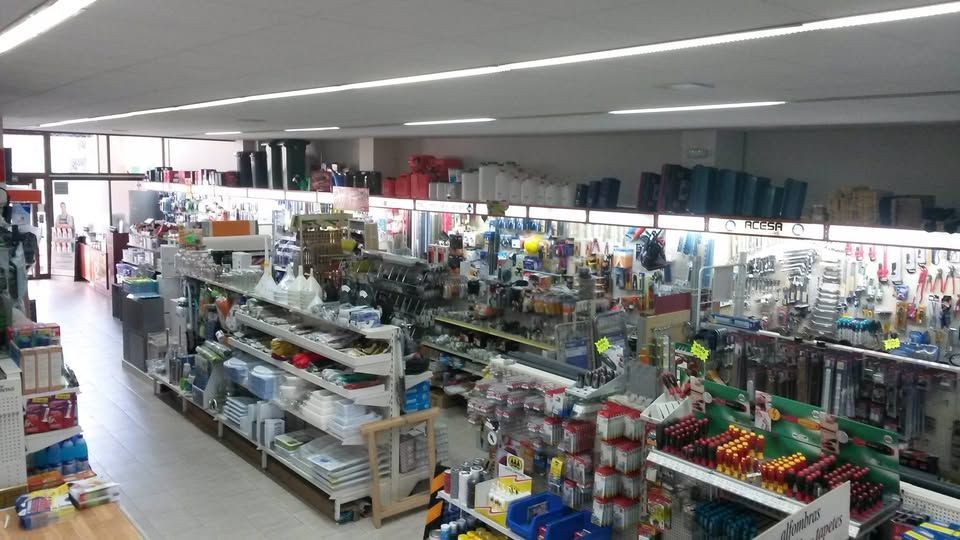 Vista desde un ángulo elevado del interior de una ferretería o tienda de mejoras para el hogar, con pasillos repletos de diversos productos.