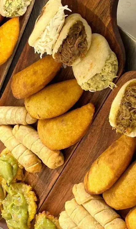 Una tabla de cortar de madera cubierta con una variedad de alimentos fritos.