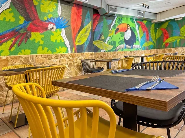 Un restaurante con mesas y sillas y un mural en la pared.