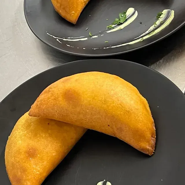 Dos platos de comida en una mesa, uno de los cuales tiene un pastel amarillo encima.