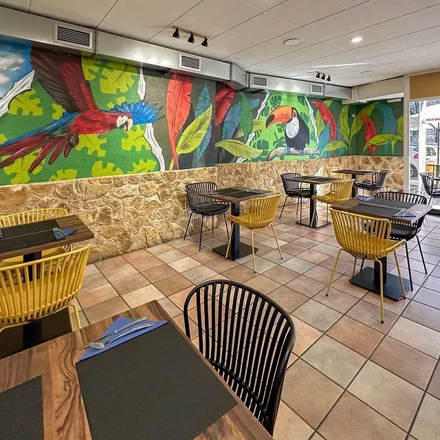 Un restaurante con mesas y sillas y un mural en la pared.