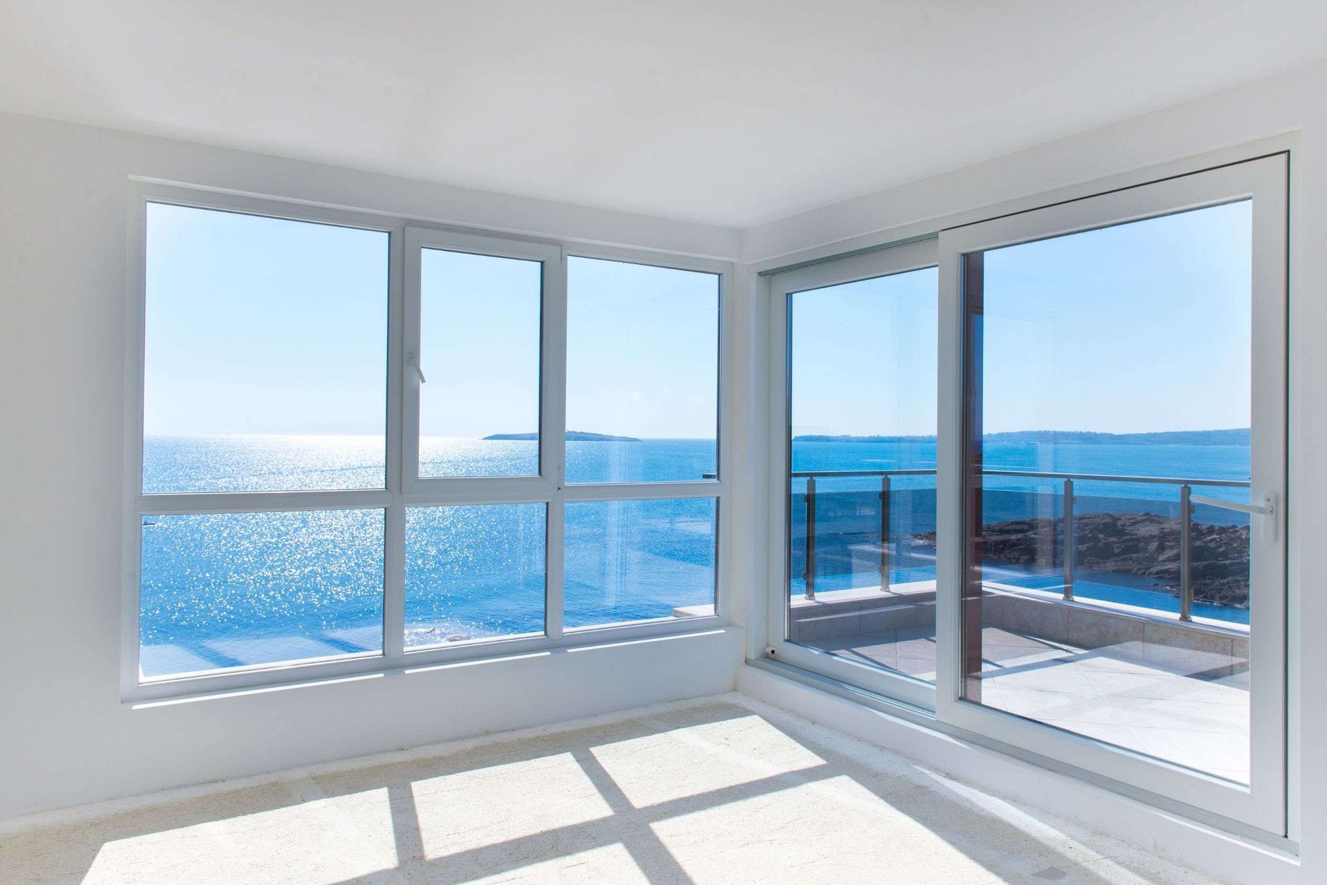 Una habitación vacía con muchas ventanas con vistas al océano.