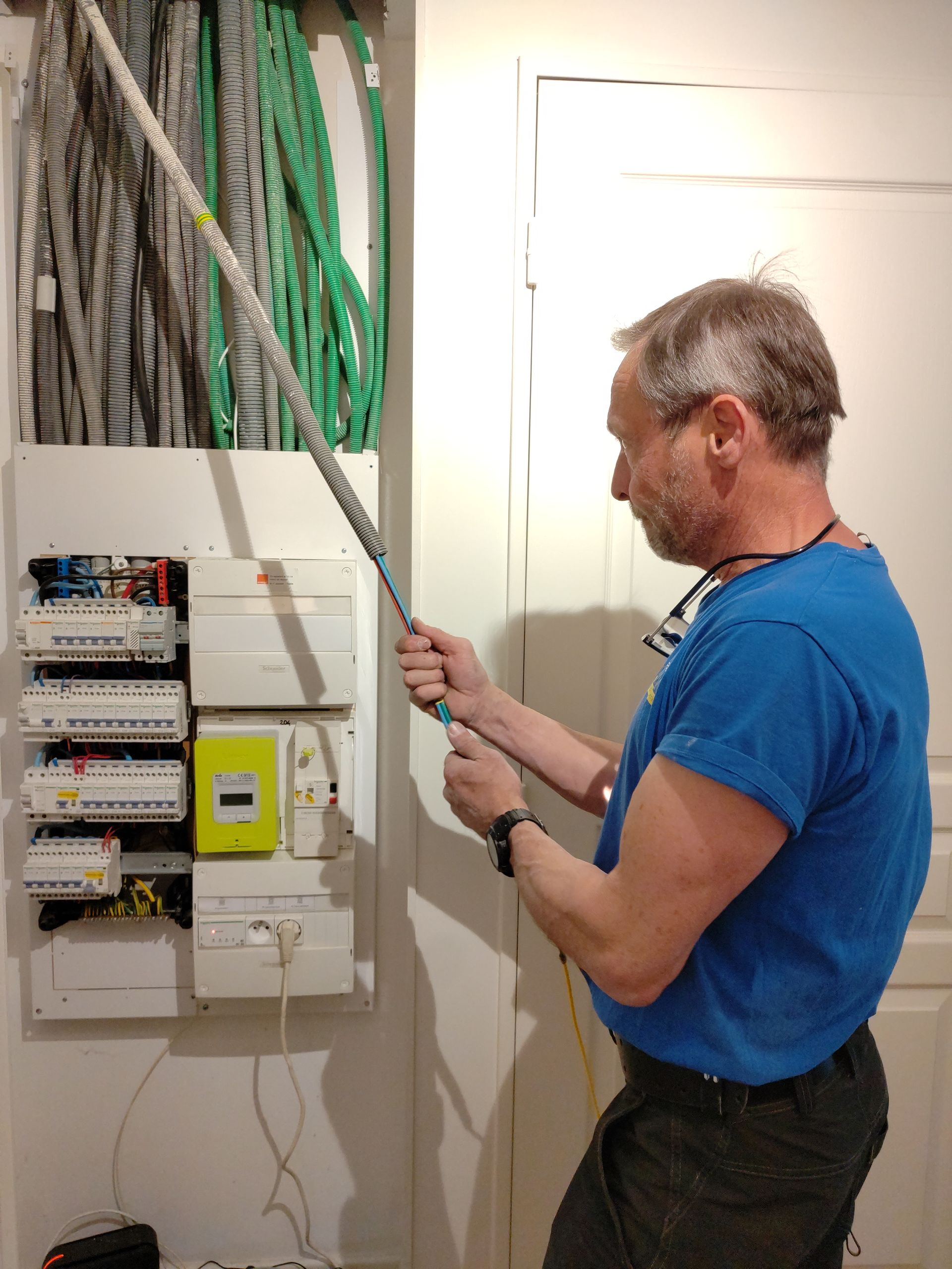 Un électricien tire un câble.
