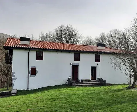 Una gran casa blanca con techo de tejas rojas